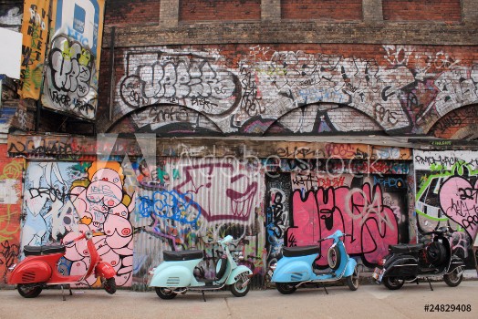 Picture of Four mopeds in front of graffiti